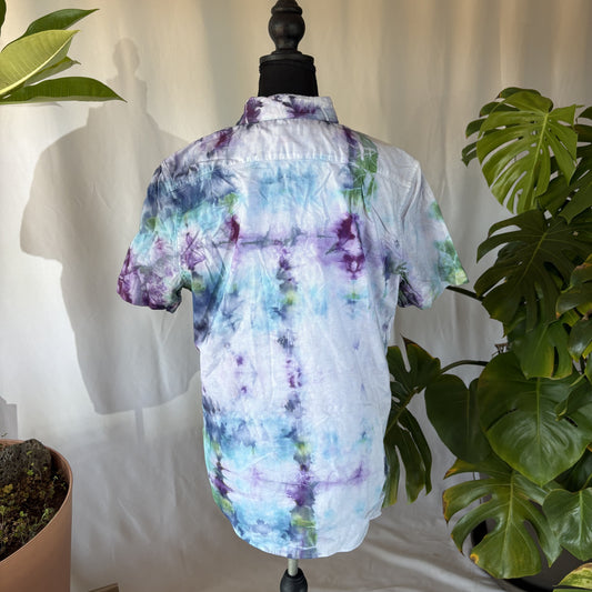 Tie-dye shirt on a mannequin with plants in the background