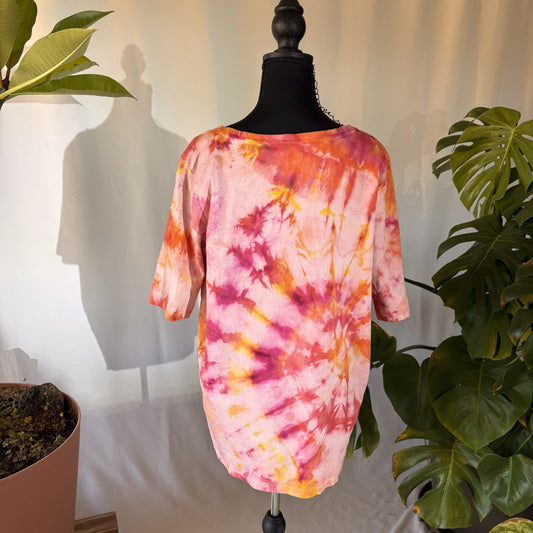 Tie-dye shirt on a mannequin with plants in the background