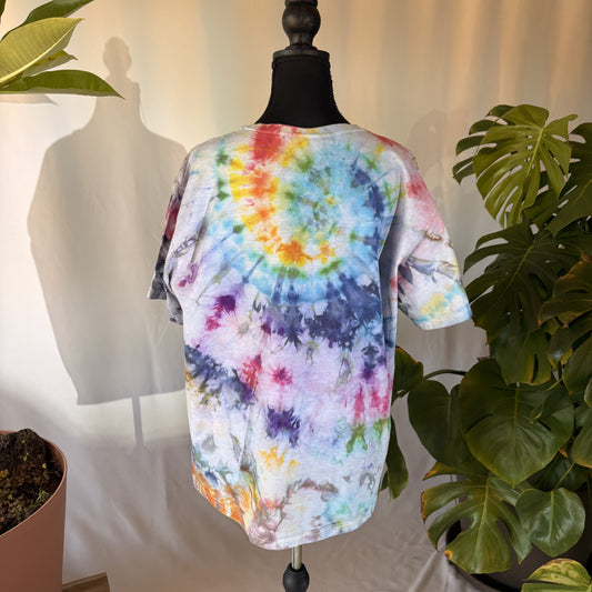 Colorful tie-dye shirt on a mannequin with plants in the background