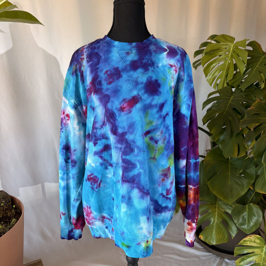 Tie-dye sweatshirt on a mannequin with plants in the background